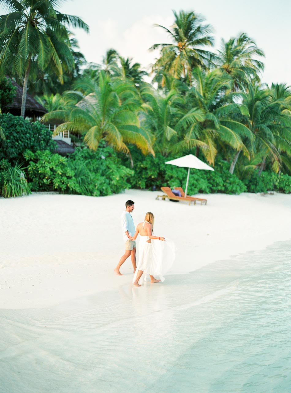 engaged couple walking in a beach in the Maldives for their honeymoon